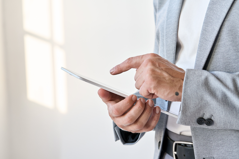 Man using his tablet to make a payment with open banking method.